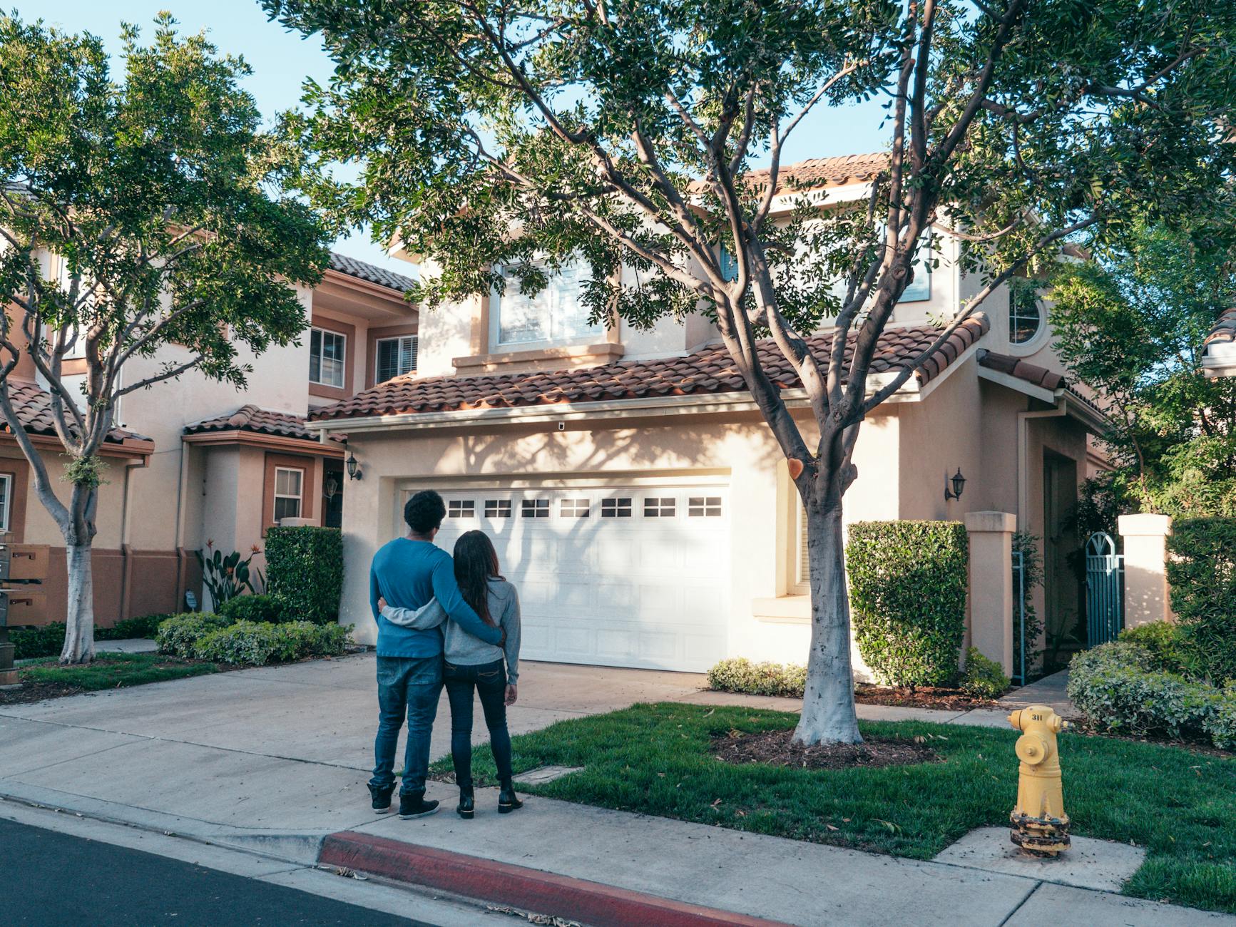 couple standing in front of their house